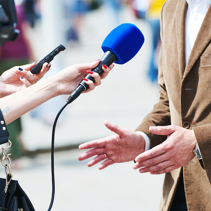 hands with a microphone pointed at someone