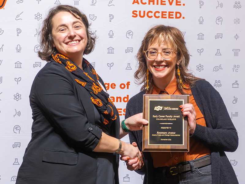 Winner Rosemary Avance holding her award on stage with Dean Cro