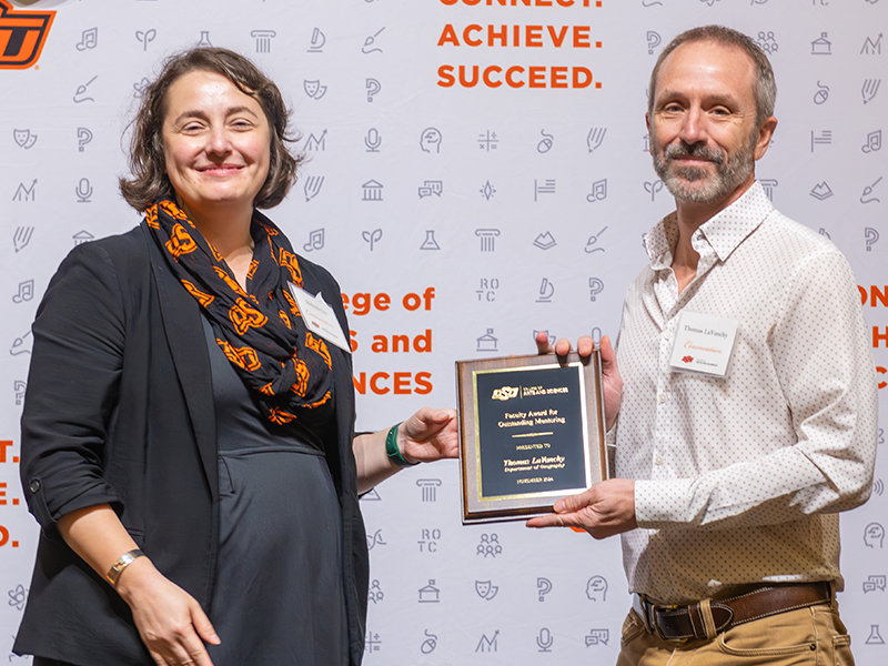 Thomas LaVancy on stage with his award and Dean Cro