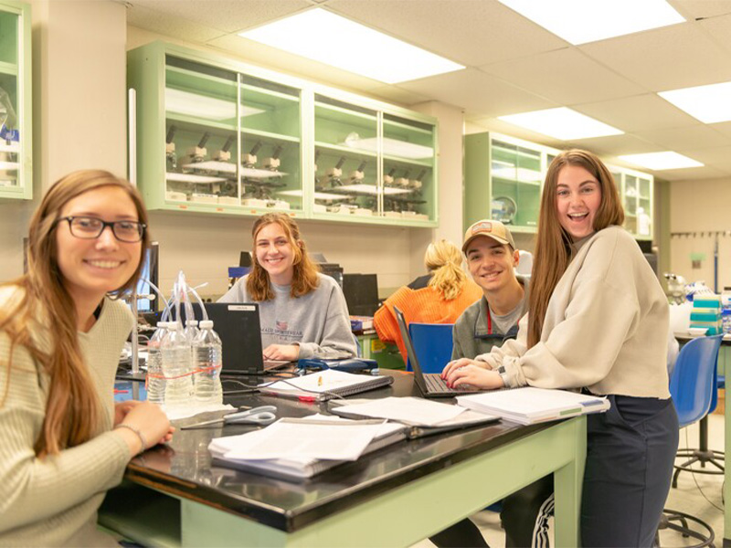 Students gathered around a table working in the lab.