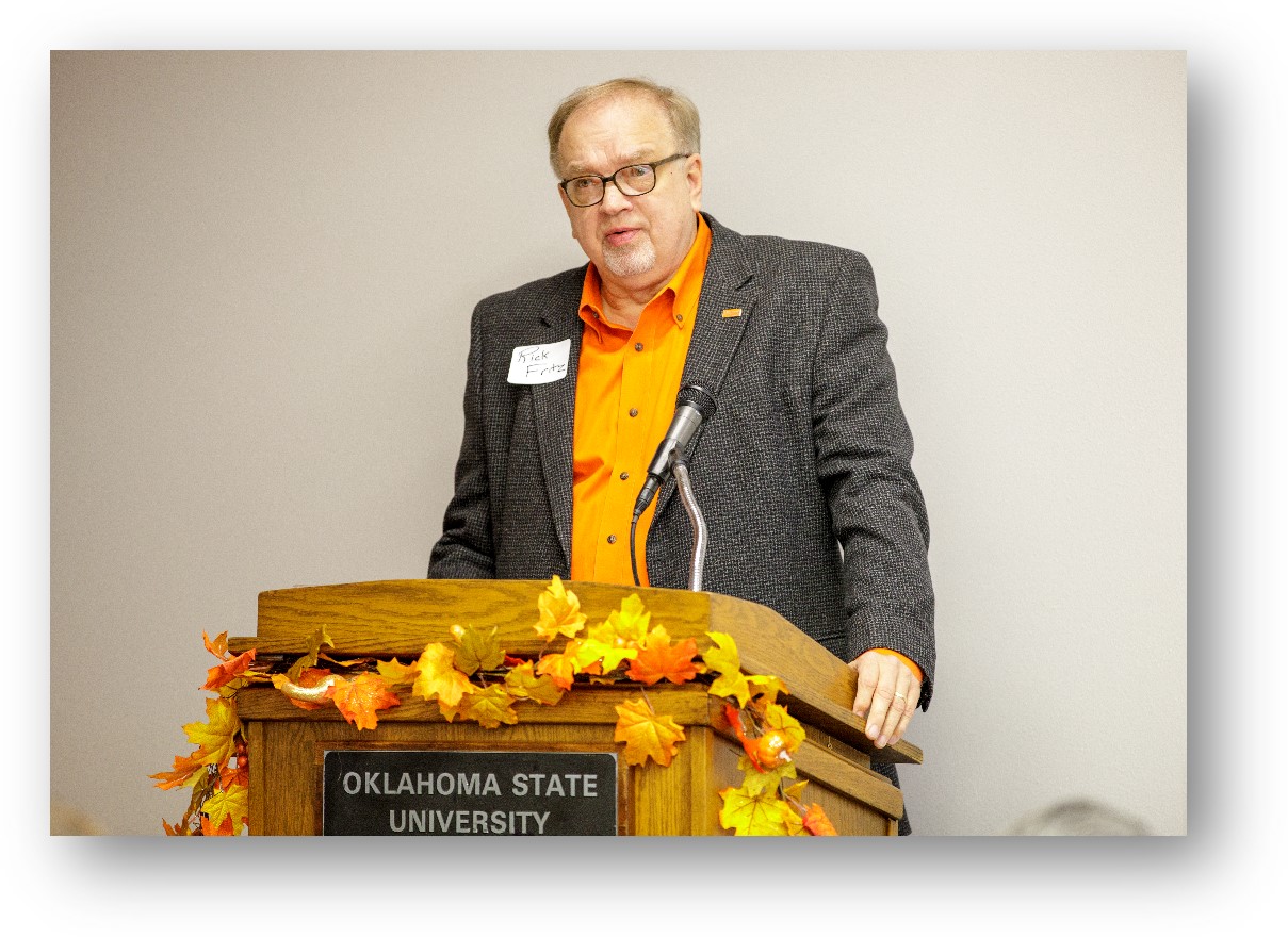 Rick Fritz, alumni member at a podium speaking to people. Rick Fritz, alumni member at a podium speaking to people.