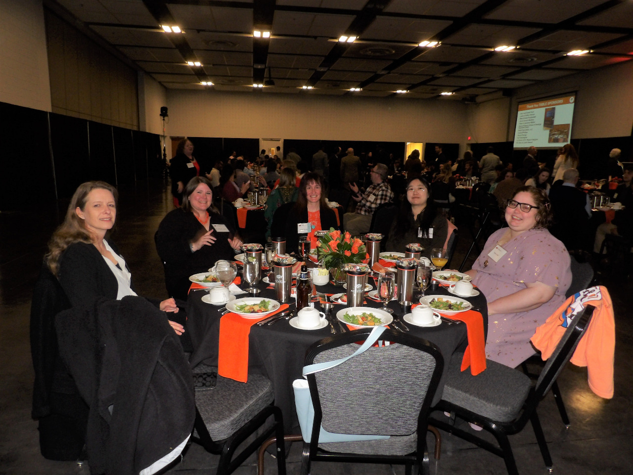 Dr. Natascha Riedinger, Dr. Michelle Abshire, Ms. Lauren Haygood, Ms. Wei Ren and Ms. Elaine Duff sitting together at dinner table visiting. Dr. Natascha Riedinger, Dr. Michelle Abshire, Ms. Lauren Haygood, Ms. Wei Ren and Ms. Elaine Duff sitting together at dinner table visiting.
