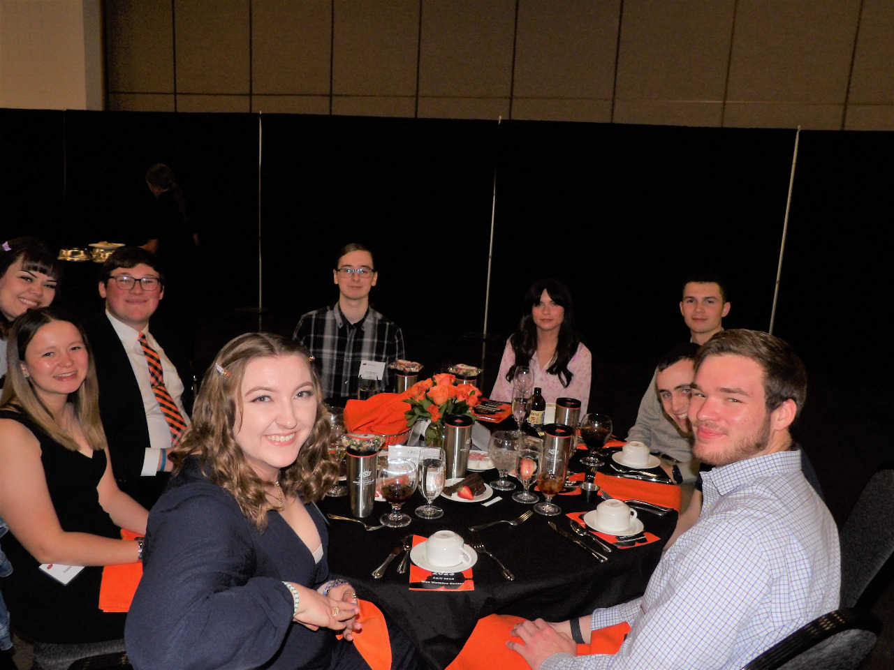 Five male and four female students hanging out at the dinner table before banquet begins. Five male and four female students hanging out at the dinner table before banquet begins.