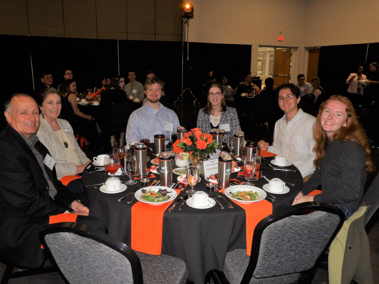Two female and two male students sitting with one male and one female alumni at the dinner table. Two female and two male students sitting with one male and one female alumni at the dinner table.