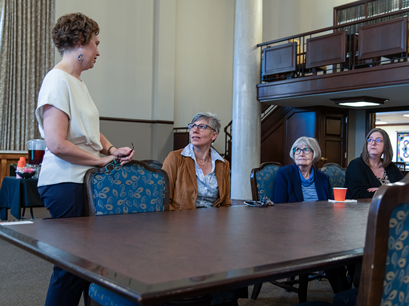 Jennifer Borland speaking to a group at a table