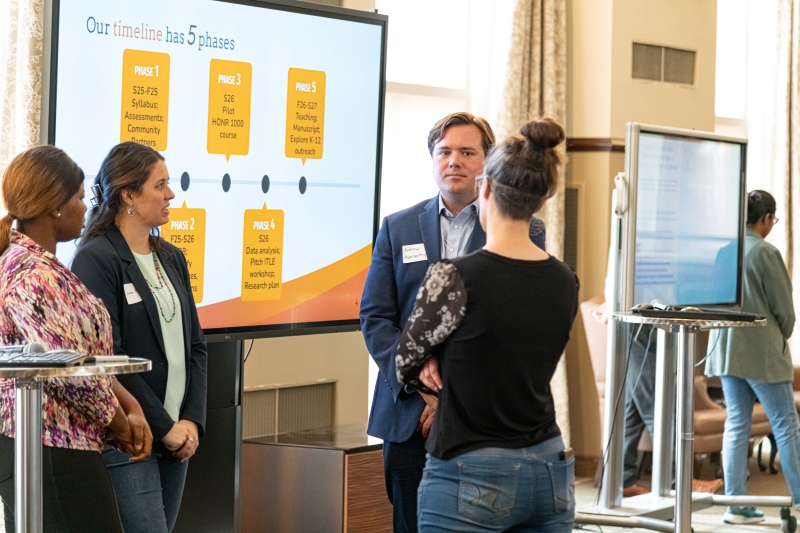 presenters speaking with audience member