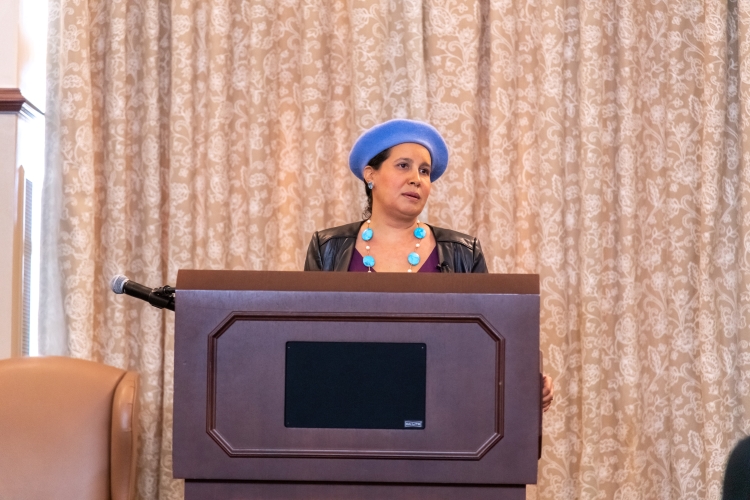 Dr. Reyes-Santos speaking at a podium.