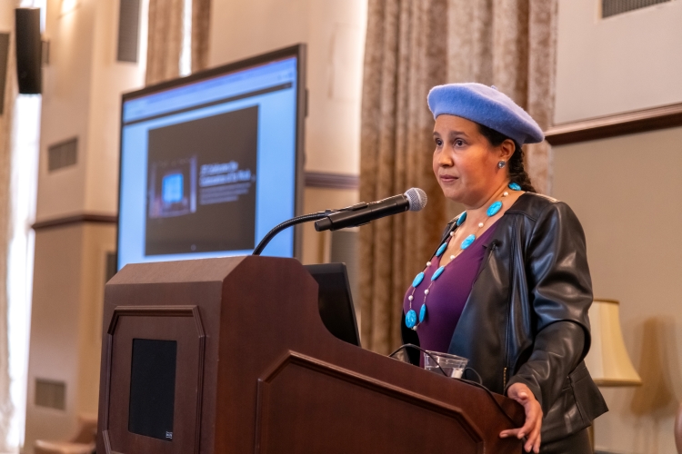 Dr. Reyes-Santos speaking at a podium.