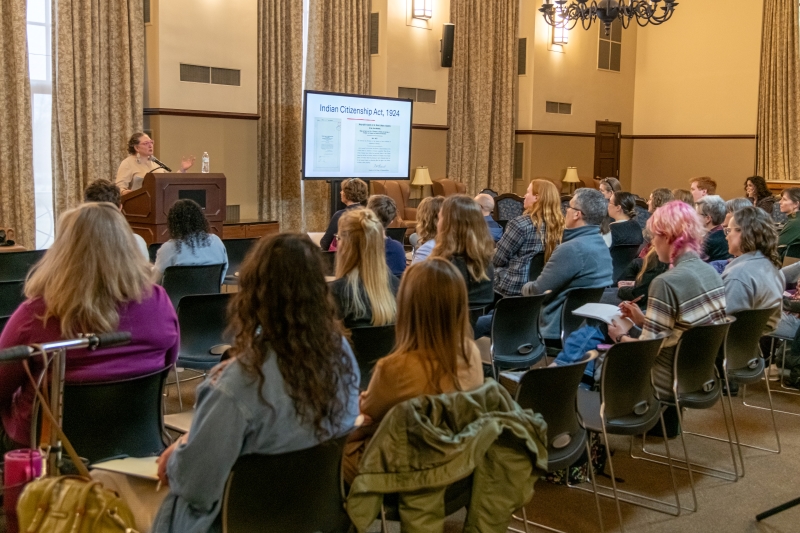 goeman at a podium in front of an audience