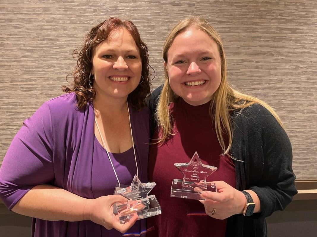 Two women laughing and looking at the camera.