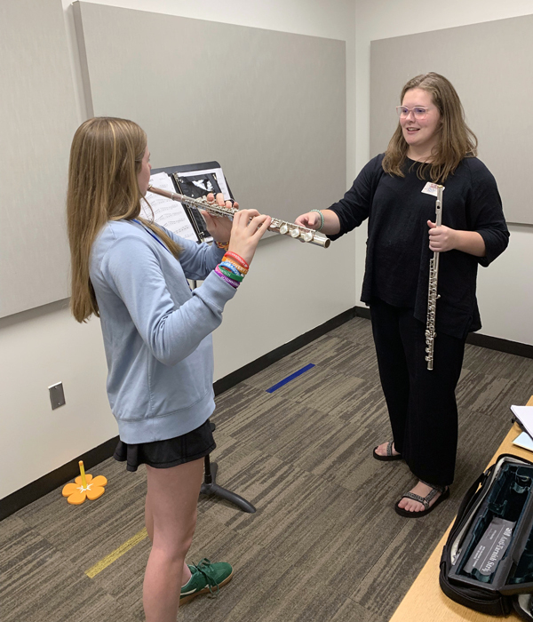 image of woman teaching flute to a young girl