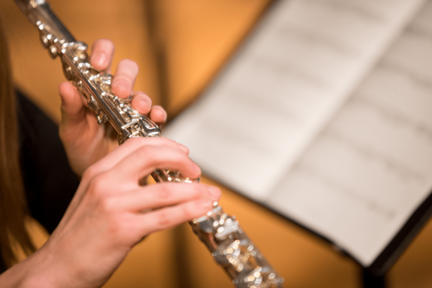 flute player's hands holding flute