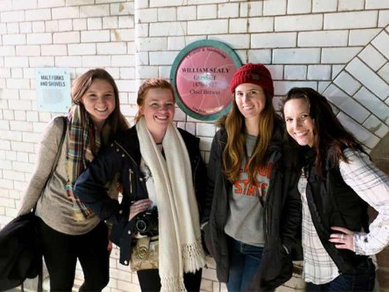 Four female students smiling at camera at the International Society of Paediatric Oncology Conference