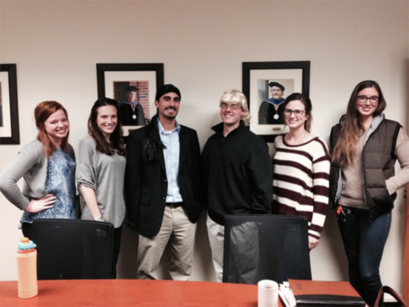 Group of students with arms around each other smiling at camera