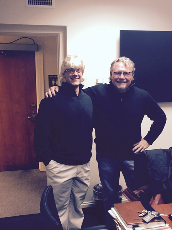 Male student dressed up like Dr. Mullins and Dr. Mullins with arms around each other smiling at camera