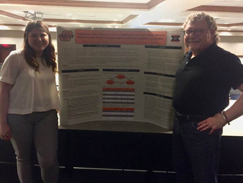 Dr. Mullins and female student in front of her poster