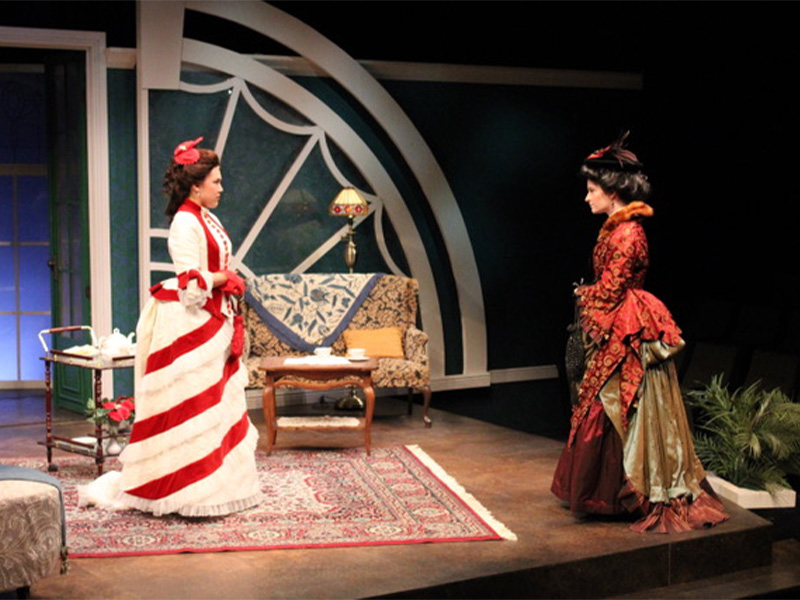 Actors on stage performing in elaborate costumes.