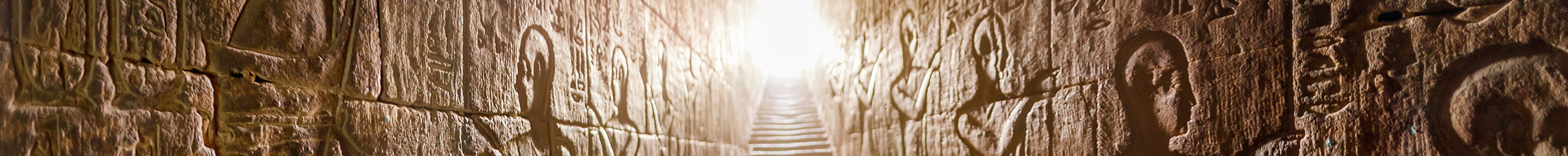 Historic stone wall with intricate carvings and a central staircase leading upward.