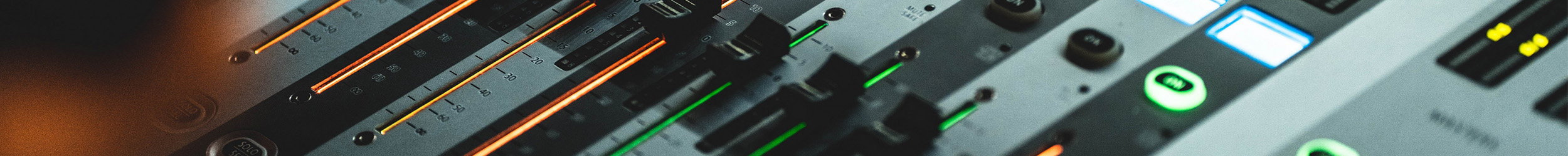 Close-up of audio controls and mixing sliders in a studio